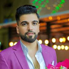 Man in pink blazer with trimmed beard holding flowers, modern setting, iPoint tech store style