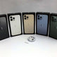 Five Apple iPhones in their boxes on a white surface with a small ring in front.