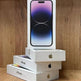 Stack of Apple iPhone boxes on a wooden surface