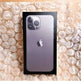Silver iPhone 11 Pro Max in packaging on a textured beige surface