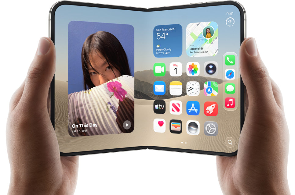 A hands-on view of a folding smartphone held open by two hands against a plain white background. The device has a black frame and a large display showing a colorful home screen interface.
